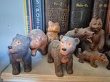 a bunch of wooden bears on a shelf in front of books