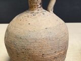 a brown vase sitting on a table with a black background
