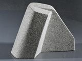 a concrete sculpture of a triangular shape on a table