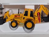 a yellow toy bulldozer in a white box