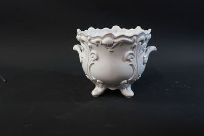 a small white vase sitting on a black surface