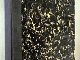 un vieux livre à la couverture noire posé sur une table