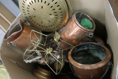 une boîte en carton remplie de casseroles en cuivre et d'une horloge