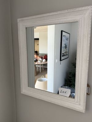 un miroir sur le mur au-dessus d'un lavabo dans une salle de bains