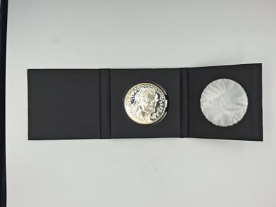 an image of a silver coin sitting on top of a black folder