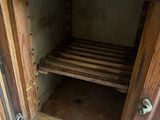 a wooden cabinet with a shelf on top of it