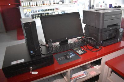 un bureau rouge sur lequel se trouvent un ordinateur et une imprimante