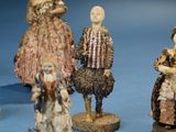 five figurines of people standing on a blue surface