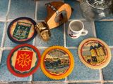many coasters that are sitting on the floor next to a cup