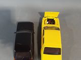 two toy cars sitting next to each other on a table