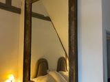 a large mirror hanging on the wall above a bed