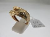 gros plan d'une bague en or sur une surface blanche avec une étiquette de prix