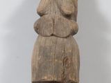 une vieille statue en bois d'un homme avec un chapeau sur la tête