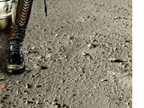 a person walking on a dirt road with boots on