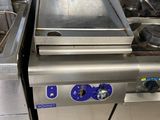 une plaque de cuisson en acier inoxydable sur laquelle est posée une poêle