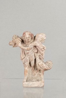 une statue représentant un ange assis sur une table en verre