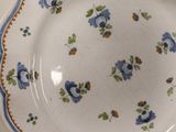 a plate with blue flowers on it sitting on a table