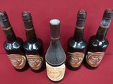 several bottles of wine are lined up on a red surface