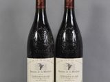 two bottles of wine sitting on top of a table next to each other
