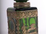 a green glass jar with a horse design on it