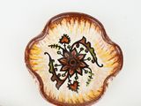 a plate with a flower design on it next to other plates