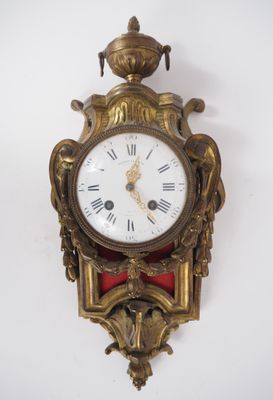 une horloge accrochée au mur, surmontée d'une couronne
