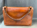 a brown leather handbag with a long strap