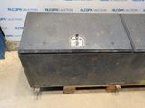 a metal box sitting on a pallet in front of a wall