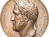 an image of a bronze medal with a man ' s head on it