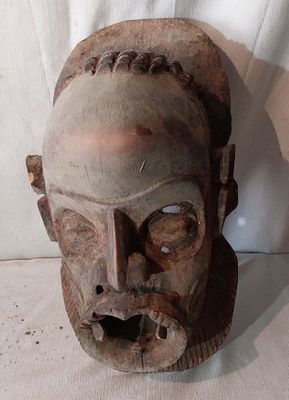 un vieux masque en bois sur fond blanc