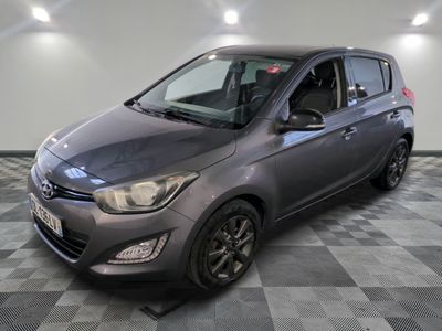 une voiture grise est garée dans une pièce au sol à carreaux