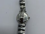 a close up of a silver watch on a white surface
