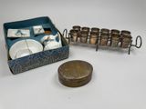 a box with cups and saucers and a coin on the table