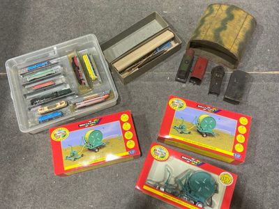 une boîte de crayons, de stylos et une boîte de gommes posées par terre