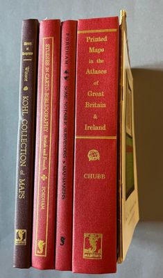 trois livres sont empilés les uns sur les autres sur une étagère