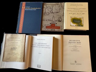 plusieurs livres ouverts posés sur une table, sur fond noir