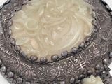 a silver plate with a carving of a woman on it