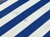 a blue and white striped beach chair on the gravel