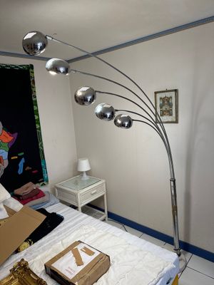a bed with a box on it and a lamp in the corner