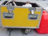 a yellow case sitting on top of a table next to two red containers