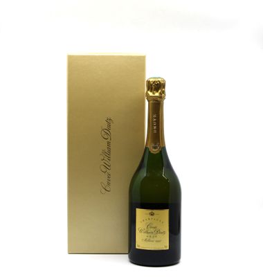 the bottle of champagne is next to a gold box on a white surface