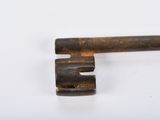 an old key that is sitting on a white surface