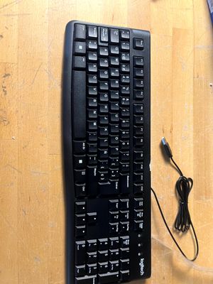 un clavier et une souris d'ordinateur posés sur une table en bois