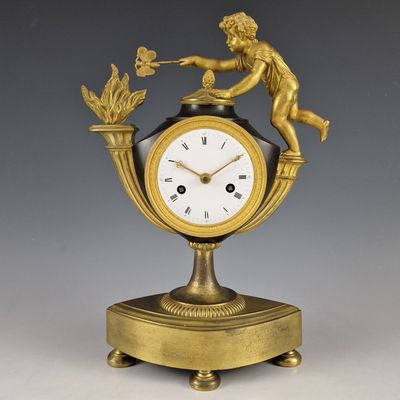 une horloge en or surmontée d'une statue