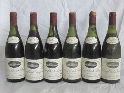 six bouteilles de vin sont alignées sur une table
