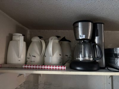 a coffee maker and other kitchen items on a shelf