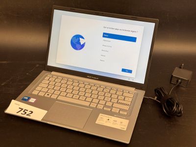 a laptop computer sitting on a table with a charger on it