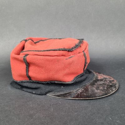 un chapeau rouge orné d'un ruban noir sur le dessus