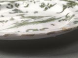 a white plate with green designs on it on a table