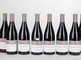 six bouteilles de vin rouge alignées sur une table